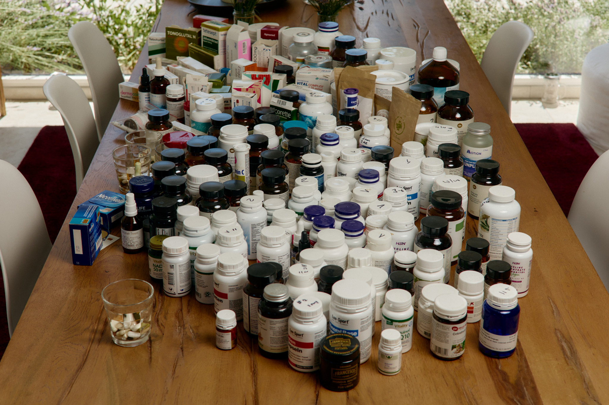 Table couverte de diverses bouteilles de médicaments et suppléments, illustrant une tentative de traitement du long Covid par Christoph Anderegg à Herisau.