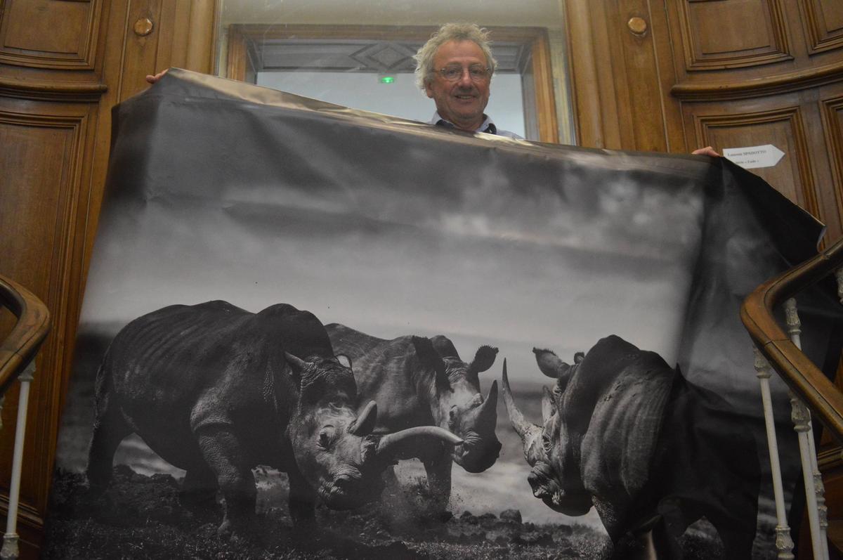 Philippe Stimaridis, président de Nouvel Œil, présente une des images de Laurent Baheux déclinée sur une grande bâche.