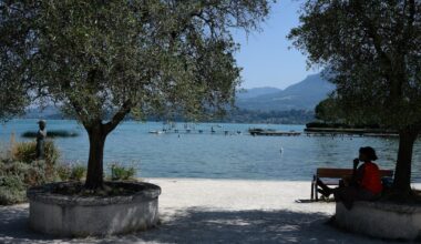 Une femme s'abrite du soleil à l'ombre d'un arbre sur une rive du lac du Bourget, au Bourget-du-Lac, en Savoie le 8 août 2025