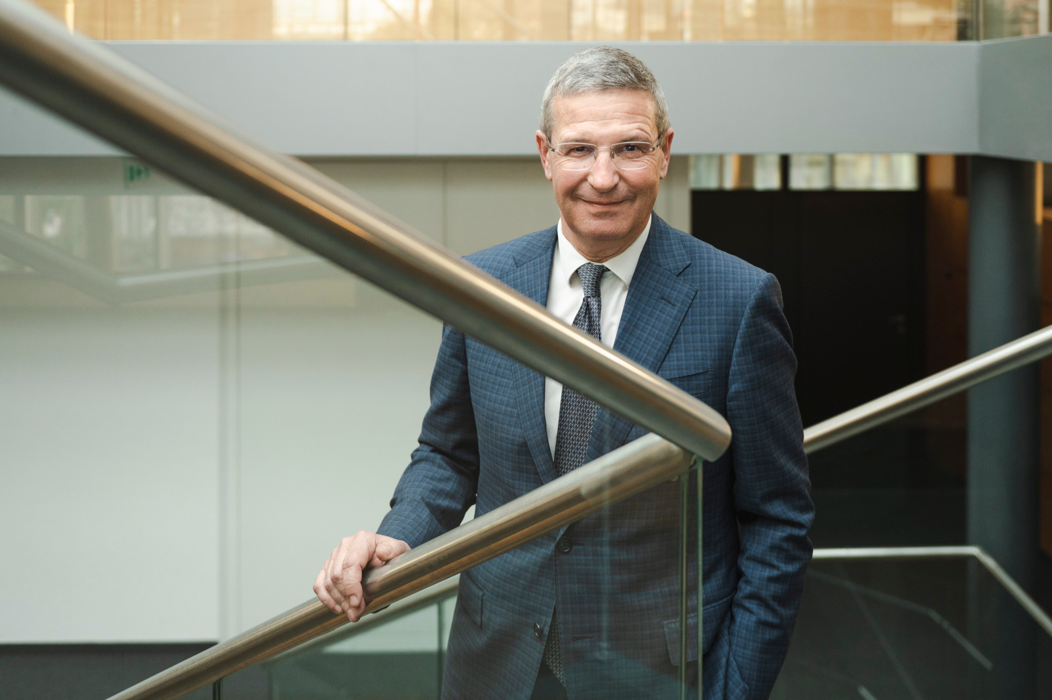 Christophe Reymond, directeur général, pose sur un escalier moderne à Paudex, discutant de l’évolution du Centre patronal.