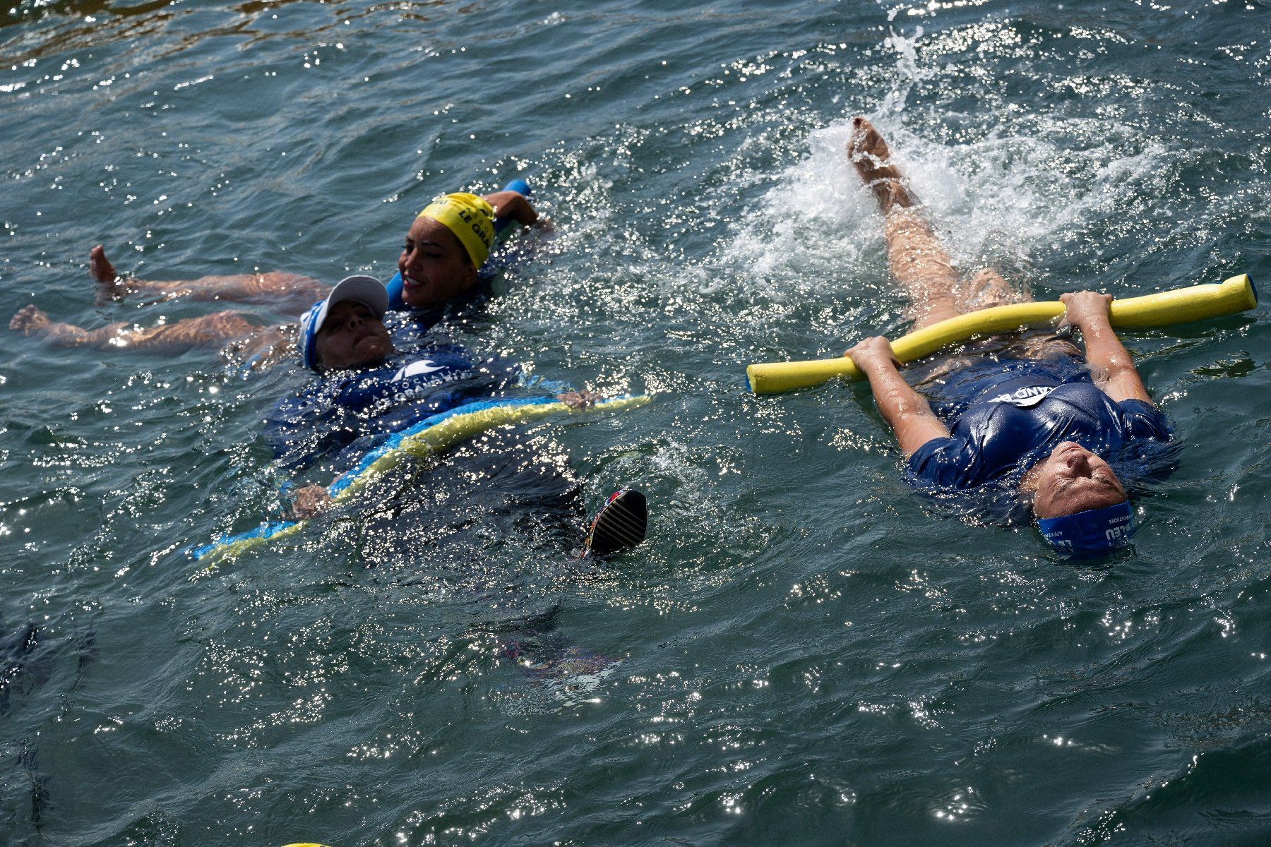 Des mères des quartiers Nord de Marseille participent à un cours de natation dispensé par l'association "Le Grand Bleu" dans une piscine d'eau de mer près du port de l'Estaque, le 11 août 2025