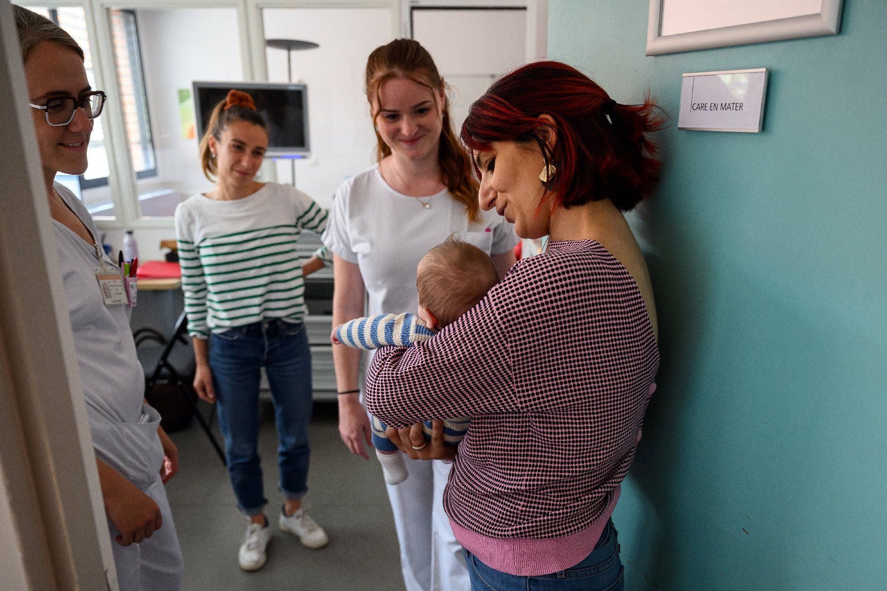 Cristina tient dans ses bras son fils Ezio aux côtés des personnels du service "Care en Mater" au centre hospitalier universitaire Purpan de Toulouse le 4 août 2025