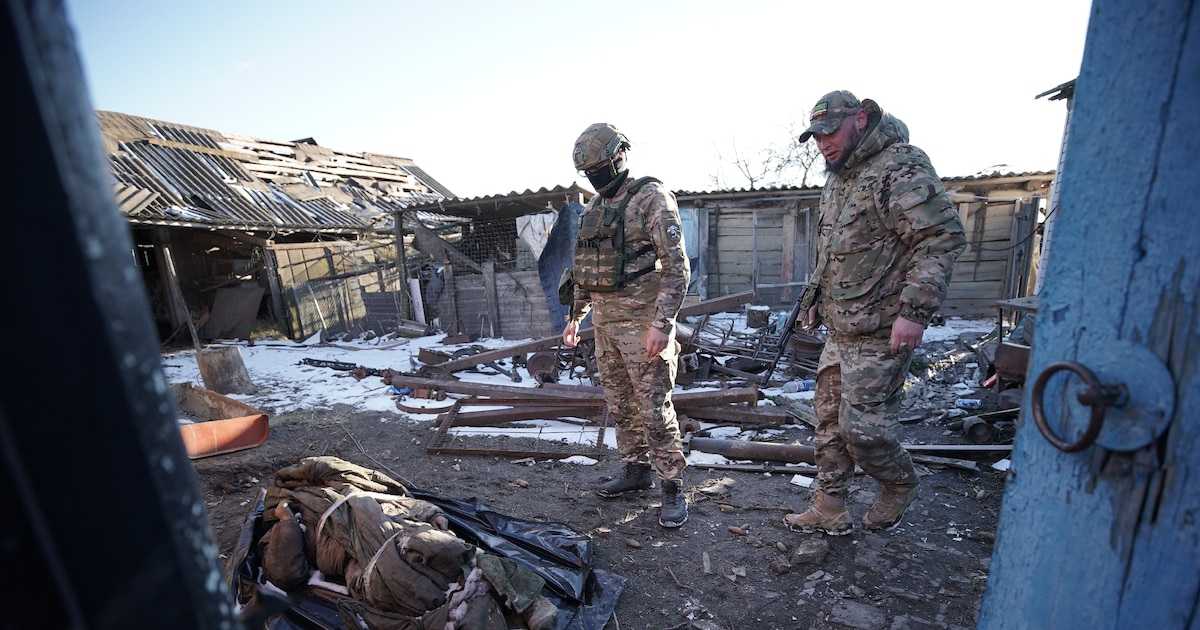Des soldats russe devant le cadavre d'un militaire ukrainien, dans le village de Kazatchïa Loknïa (région de Koursk, Russie) le 19 mars 2025