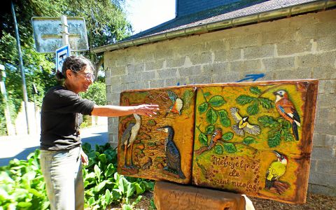 Nolwenn Depin devant l'enseigne qui signale le refuge de la Ligue de protection des oiseaux de la prairie Saint-Nicolas qui jouxte son atelier. Une commande de la municipalité de Quimperlé.