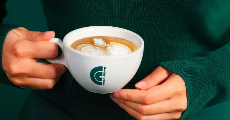 Gros plan sur une personne tenant une tasse de café.