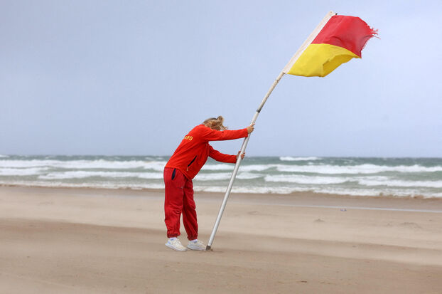 Un sauveteur a érigé un drapeau pendant la tempête Floris sur la côte nord de l'Irlande du Nord, à Portstewart. Reuters/Cathal McNaughton
