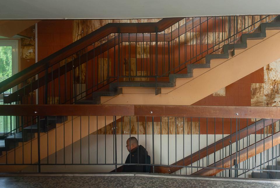 Un homme entre deux cages d'escalier 