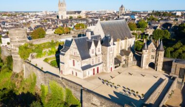 Une vue aérienne d’une ville avec un château en arrière-plan.