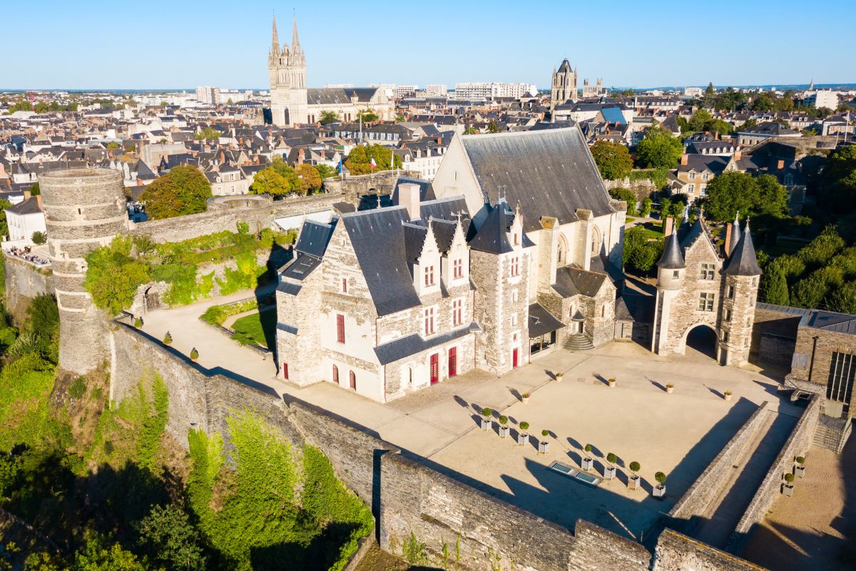 Une vue aérienne d’une ville avec un château en arrière-plan.