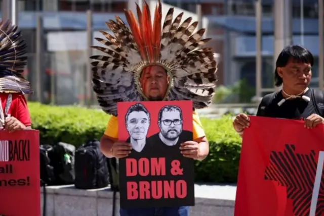 Des autochtones brandissent des affiches rendant hommage à Dom et Bruno, sur lesquelles figurent des images des deux hommes.