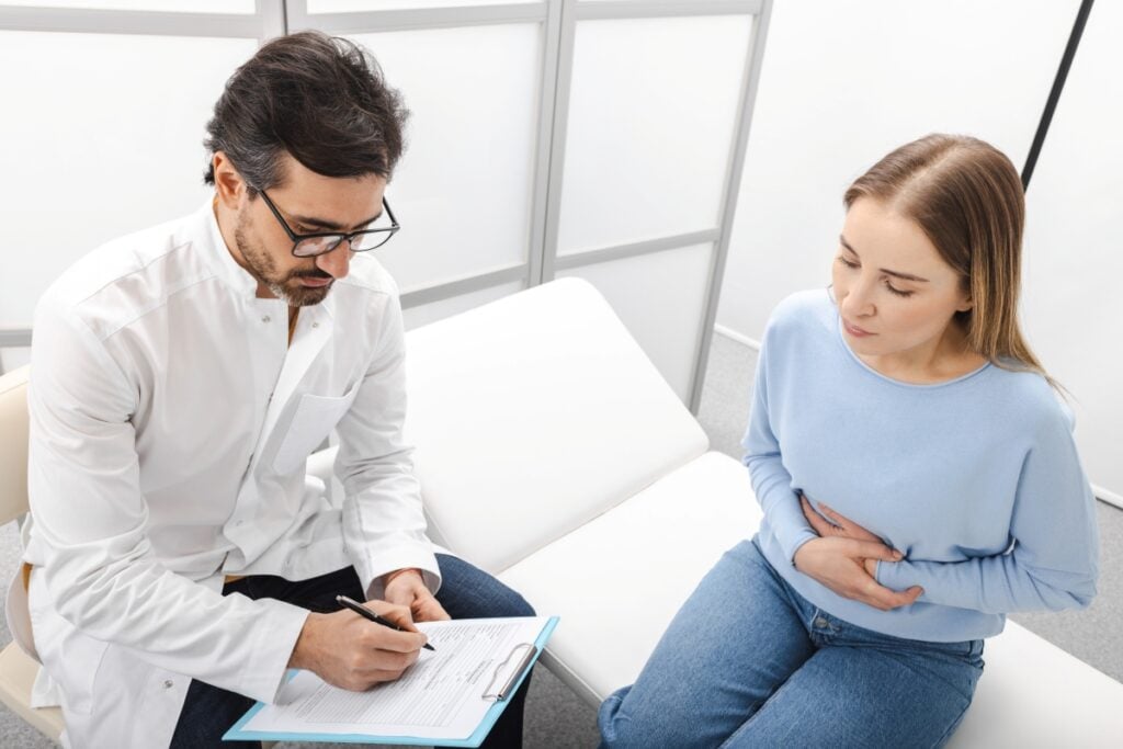 Femme souffrant de douleurs abdominales lors d'une consultation avec un gastro-entérologue