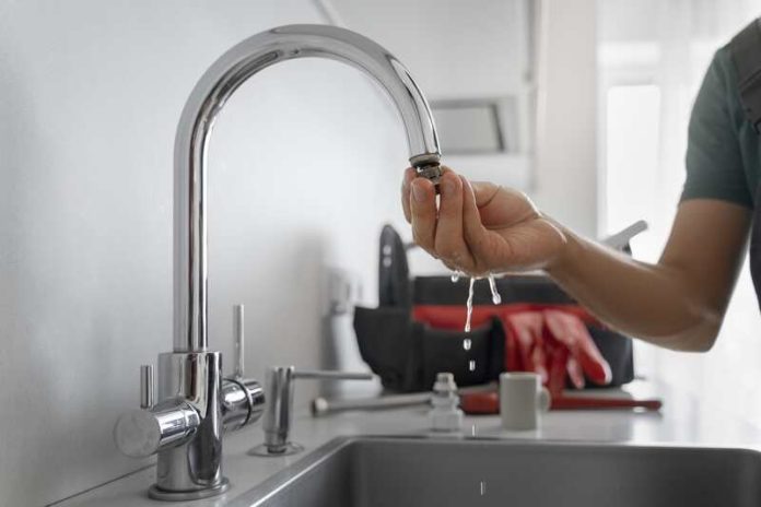 filtres eau du robinet qualité pollution polluant pfas minéraux Ma Santé Un homme qui installe un filtre à eau sur son robinet.