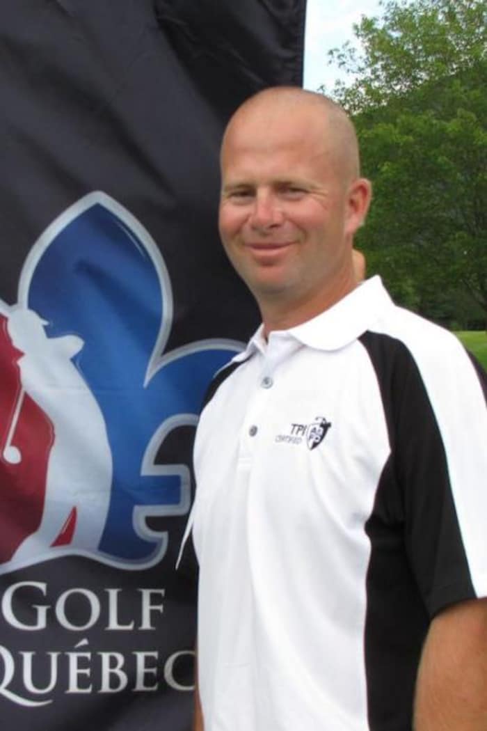 Un homme en blanc devant une bannière de Golf Québec