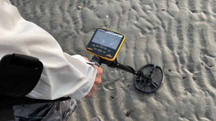 Le détecteur de métaux signale la présence de pièces de monnaie égarées dans le sable. (NICOLAS JOLY / RADIO FRANCE)