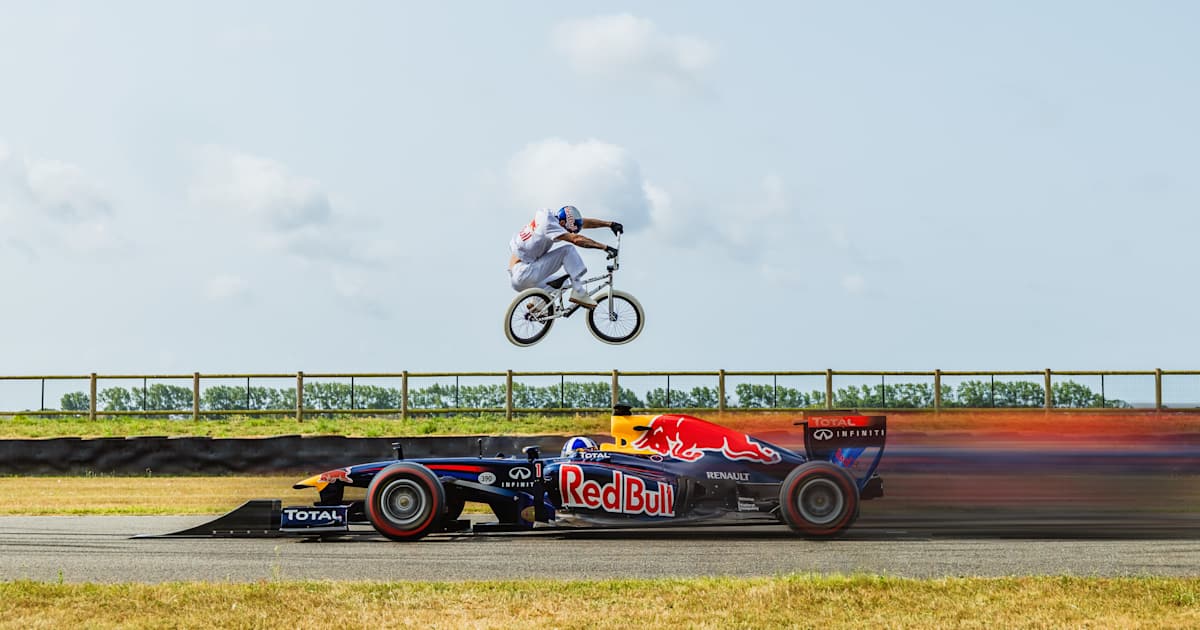 un pro du BMX saute par-dessus une F1