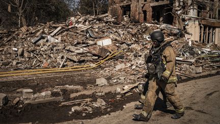 Un soldat ukrainien marche devant un immeuble en ruines, le 2 août 2025 à Kramatorsk (Ukraine). (NICOLAS CLEUET / LE PICTORIUM / MAXPPP)