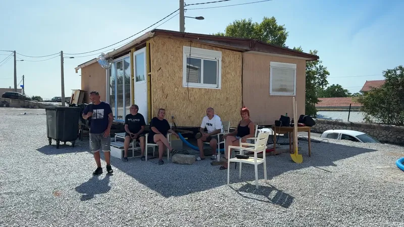 Des familles réunies, non loin du terrain calciné. Entre solidarité et débrouille, ils prennent en main l’installation de leurs nouveaux logements.