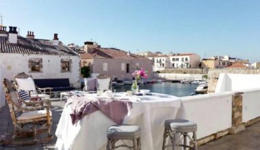 Table dressée sur une terrasse avec vue sur des bateaux