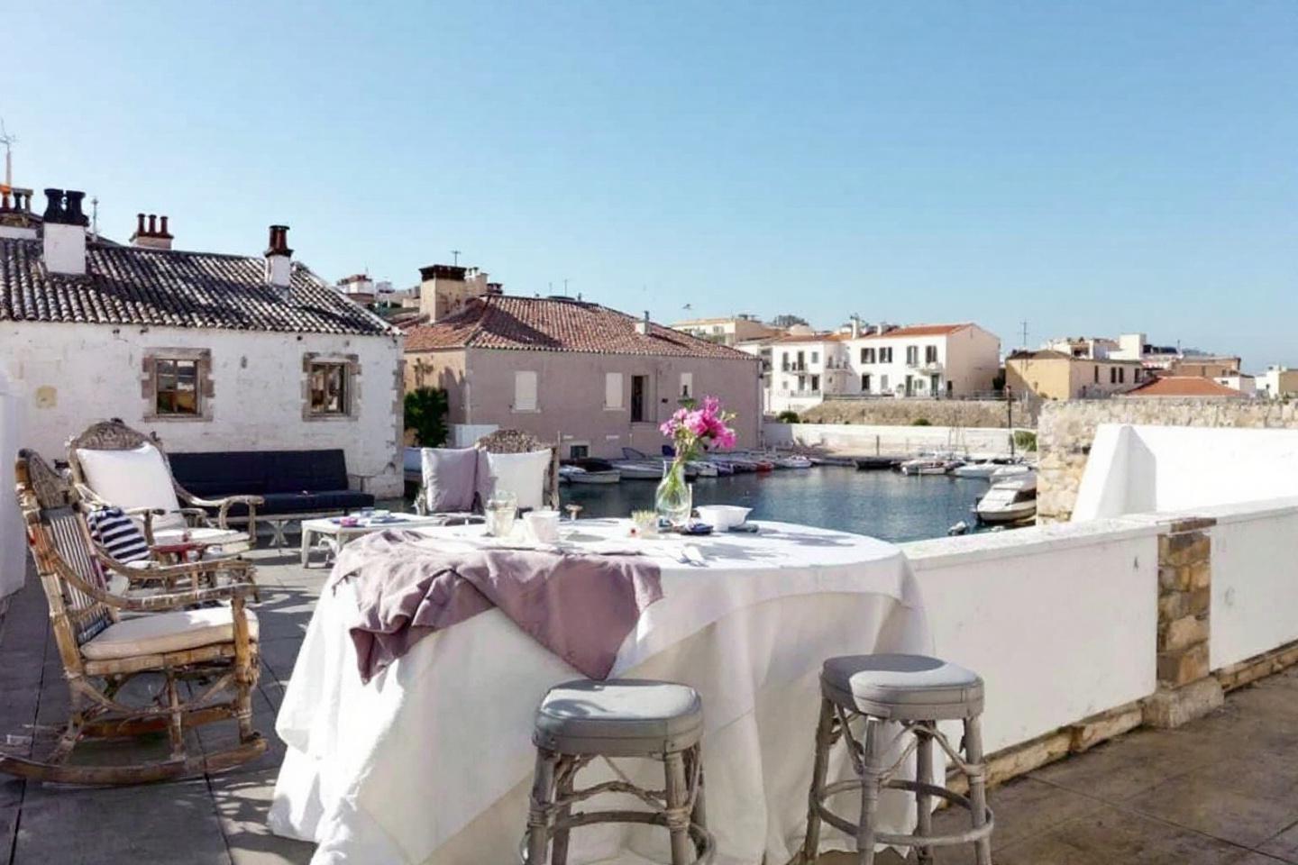 Table dressée sur une terrasse avec vue sur des bateaux