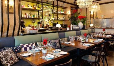Intérieur de restaurant avec tables en bois, banquettes et luminaires