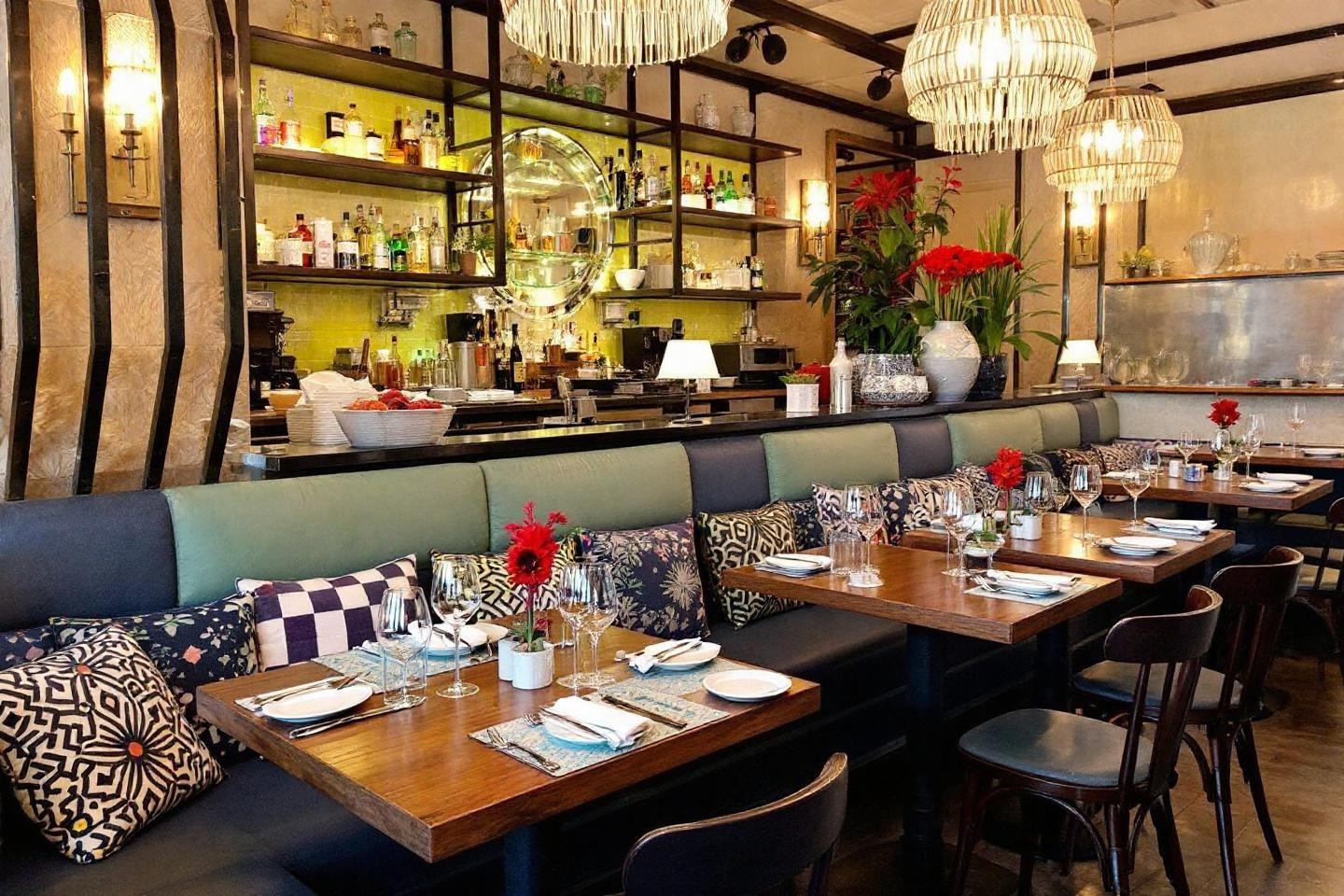 Intérieur de restaurant avec tables en bois, banquettes et luminaires
