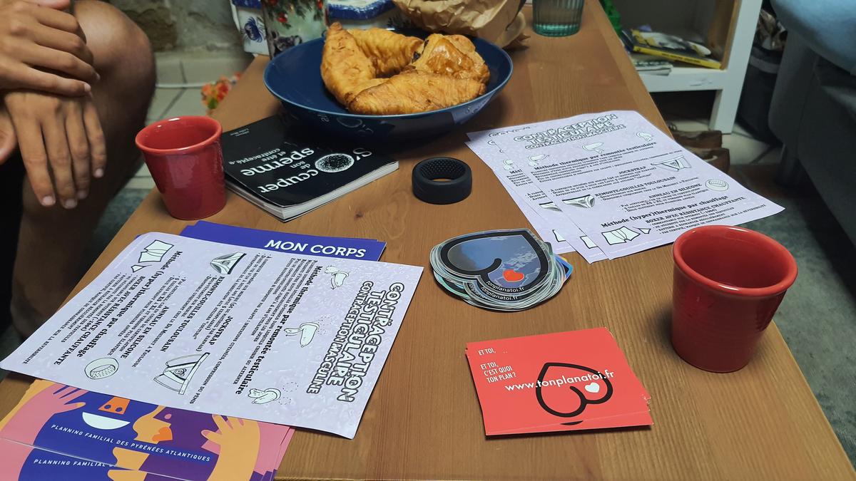 Sur la table : café, croissants, brochures… Et anneau contraceptif.