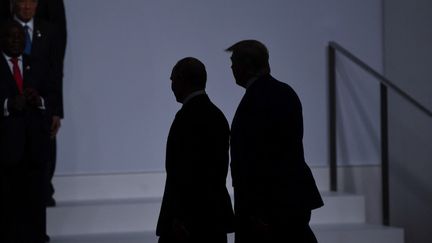 Le président américain Donald Trump marche avec le président russe Vladimir Poutine, lors du sommet du G20 à Osaka, au Japon, le 28 juin 2019. (BRENDAN SMIALOWSKI / AFP)