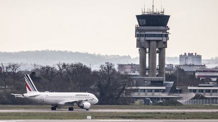 Un avion d'Air France passe devant la tour de contrôle de l'aéroport de Toulouse-Blagnac, à Cornebarrieu (Haute-Garonne), à 14 mars 2025. (FREDERIC SCHEIBER / HANS LUCAS / AFP)
