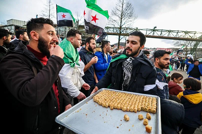 Des Syriens brandissent des drapeaux de l'opposition lors d'un rassemblement spontané à Wuppertal, en Allemagne, après la chute du gouvernement de Bachar al-Assad.