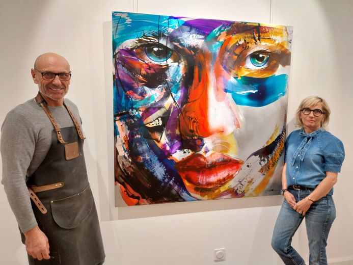Philippe et Karine, qui assurera l'accueil au quotidien à la galerie Fannyart, présentent un des portraits colorés de Fabiola Govare..