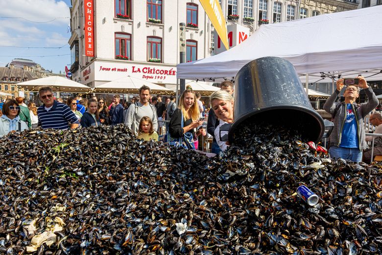 Une restauratrice vide un tas de coquilles de moules à la braderie de Lille.