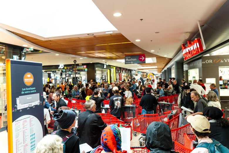 Les manifestants rassemblés avant que l’hypermarché décide momentanément de baisser son rideau de fer.