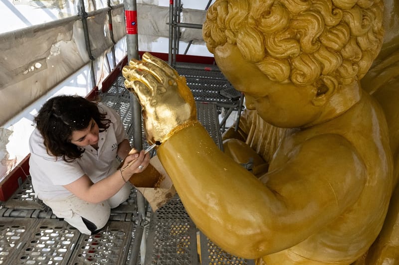 La restauratrice d'art Cyrielle D'Antoni travaille avec des feuilles d'or sur la statue de Jésus, à côté de la Vierge Marie, lors de la rénovation de la basilique Notre-Dame de la Garde à Marseille, le 3 septembre 2025