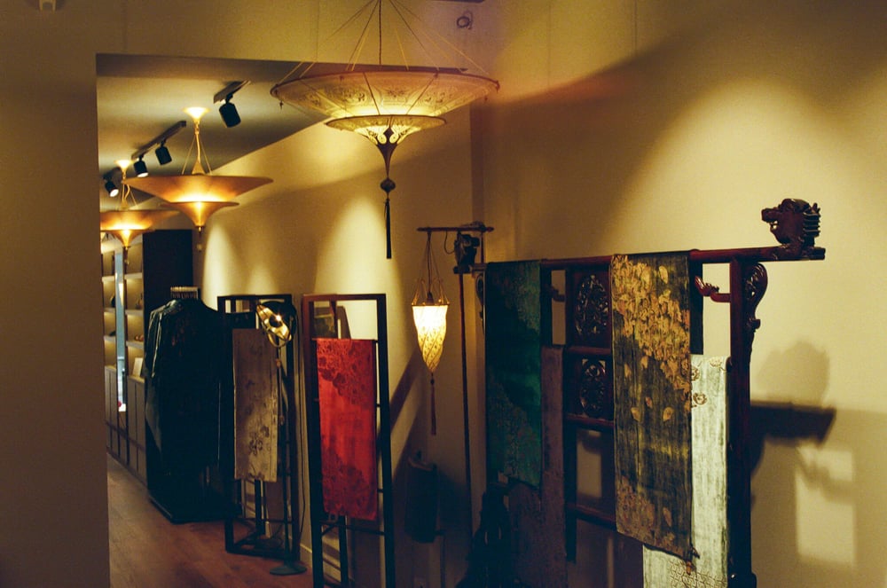 L'intérieur de la nouvelle boutique parisienne de Fortuny, qui expose des textiles en soie et des luminaires de marque dans un espace raffiné et immersif.