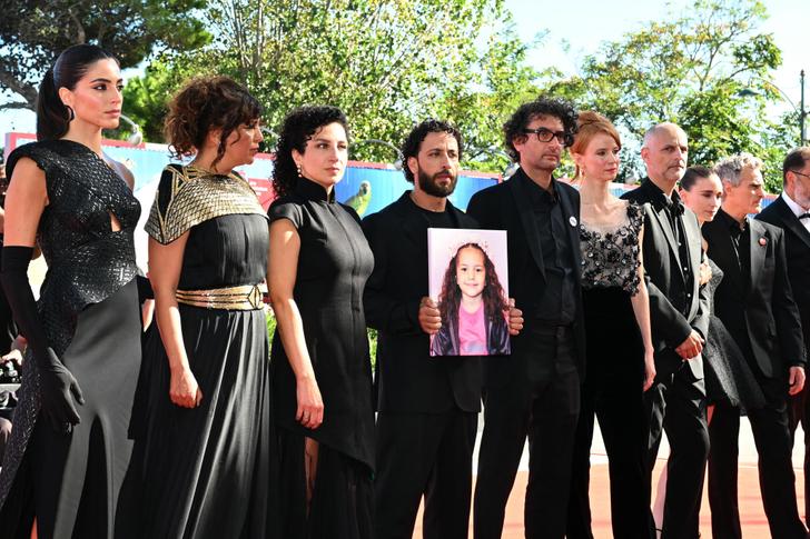 From left : Actress Saja Kilani, Tunisian director Kaouther Ben Hania, actress Clara Khoury  actor Motaz Malhees, and producers Nadim Cheikhrouha, Odessa Rae, Jim Wilson, Rooney Mara, Joaquin Phoenix, pose with a portrait of late Palestinian girl Hind Rajab, during  the red carpet for the movie "The Voice of Hind Rajab" presented in competition at the 82nd International Venice Film Festival, at Venice Lido on September 3, 2025. (Photo by Stefano RELLANDINI / AFP)