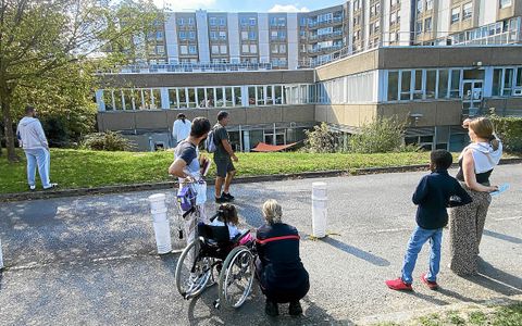Les enfants hospitalisés regardent les pompiers descendre en rappel pour frapper aux fenêtres des enfants hospitalisés dans des chambres stériles.