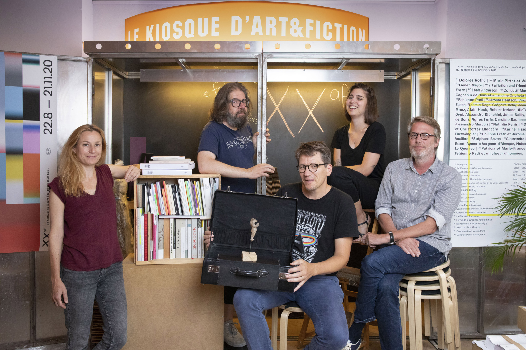 Cinq personnes posent devant Le Kiosque d’art&fiction à Lausanne pour célébrer les 20 ans de publications de livres d’art.