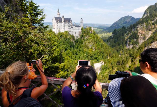 Des touristes prennent en photo le château de Neuschwanstein, en Bavière, en Allemagne, le 15 août 2013.