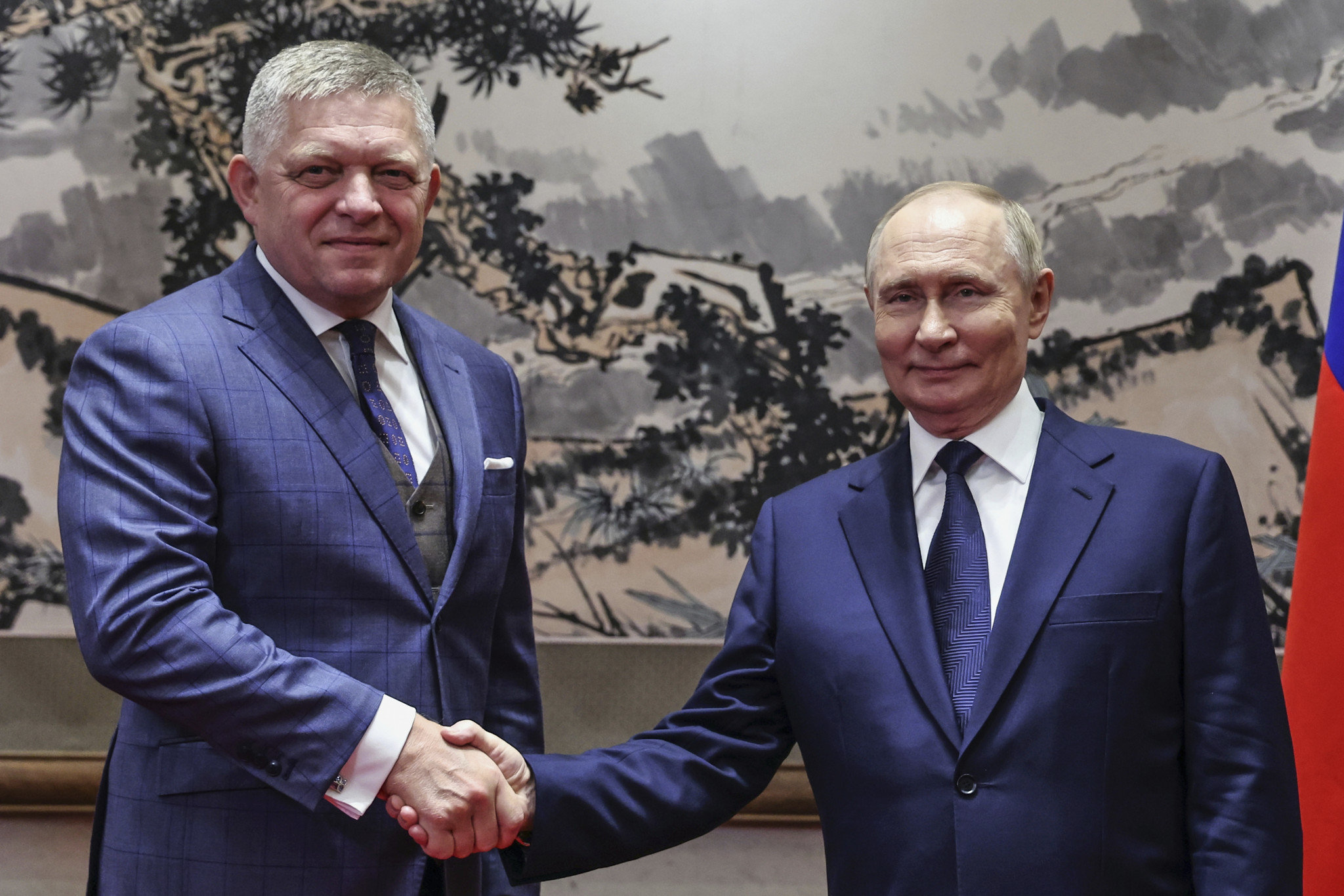 Le président russe Vladimir Poutine et le Premier ministre slovaque Robert Fico se serrent la main lors de leur rencontre à la maison d’hôtes d’État de Diaoyutai à Pékin, Chine.