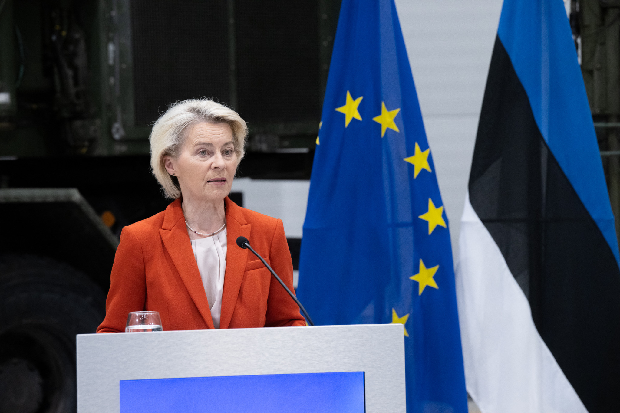 Ursula von der Leyen, présidente de la Commission européenne, s’adresse aux journalistes à la base militaire Amari en Estonie, avec les drapeaux de l’UE et de l’Estonie en arrière-plan.