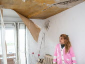 Amina pose aux côtés des toiles et du plafond endommagés, qui se sont abattus dans son salon dans la nuit du 21 au 22 septembre. Photo Cyril Lestage