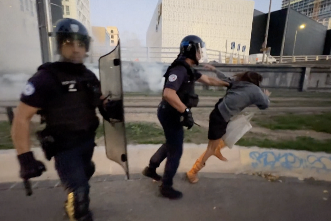 une manifestante frappée et jetée à terre par des CRS