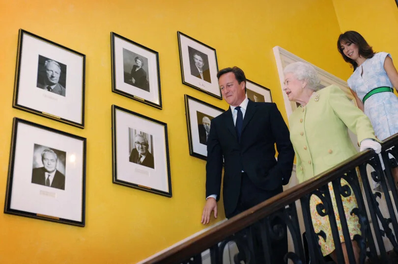 Élisabeth II et le Premier ministre David Cameron et son épouse Samantha dans les escaliers du 10 Downing Street, en 2011.