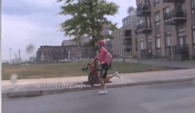 Neilson Powless contraint de courir avec son vélo sur l'épaule pour rattraper la voiture de son équipe et se faire dépanner