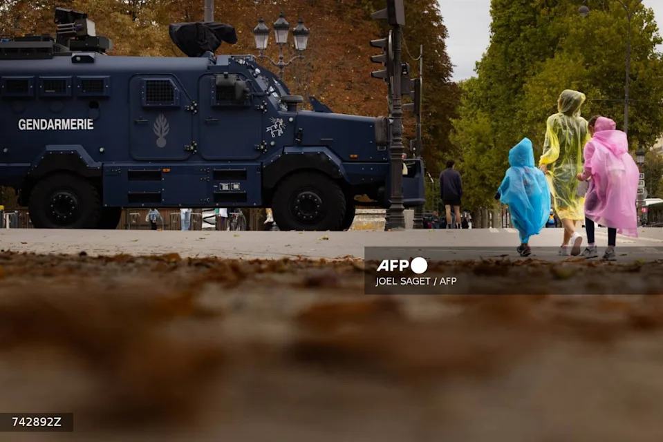 <span>Des touristes passent devant des véhicules de la gendarmerie le 10 septembre sur l'avenue des Champs-Elysées</span><div><span>JOEL SAGET</span><span>AFP</span></div>