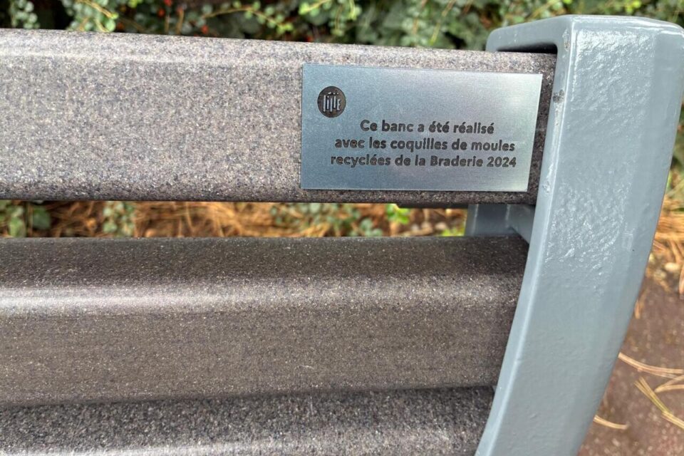Une petite plaque est installée sur chaque banc fabriqué avec des coquilles de moules.