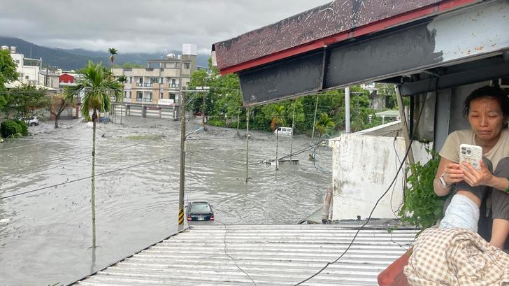 Une habitante sur le toit d’une maison, alors que l’eau d’un barrage et inonde la région de Hualien, à Taïwan, le 23 septembre 2025.