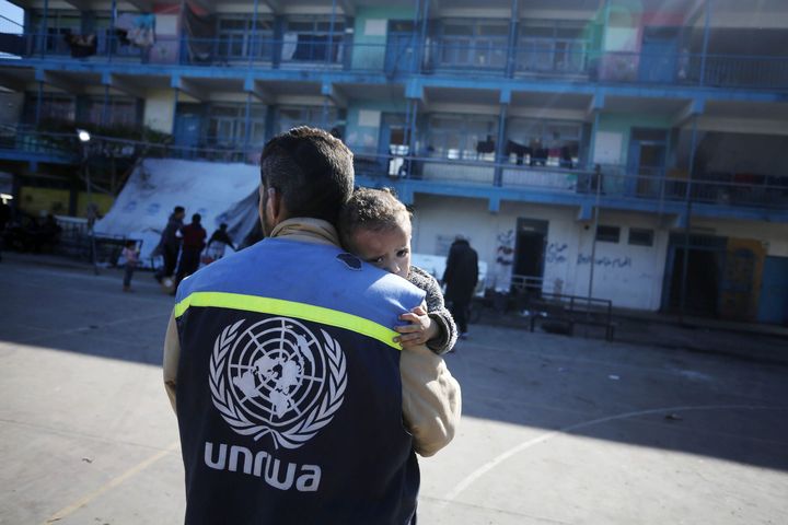 Un membre de l'équipe de l'UNRWA transporte un enfant blessé à travers une école transformée en abri dans le centre de Gaza, l'un des 150 abris d'urgence gérés par l'UNRWA, en janvier 2024. (THYSSEN MUSEO MADRID)