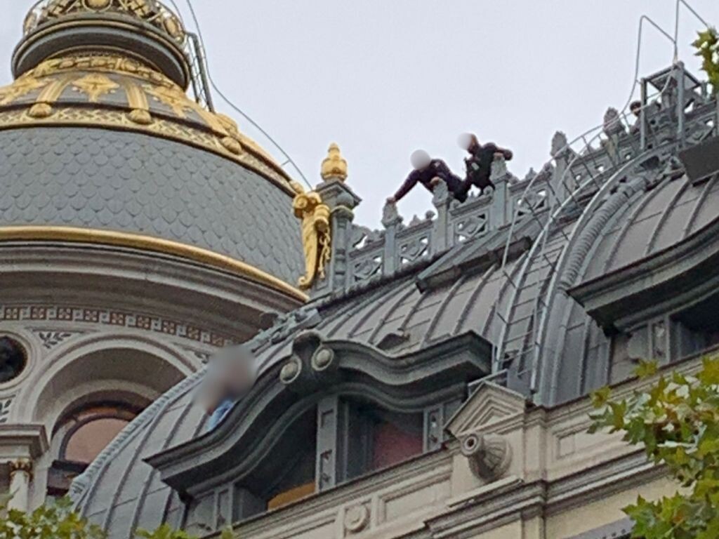 une femme, juchée sur le toit du magasin Printemps Haussmann maîtrisée par les pompiers