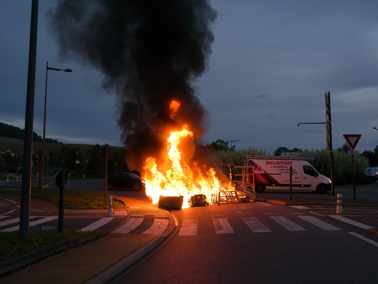 des manifestants bloquent un rond-point, un feu allumé